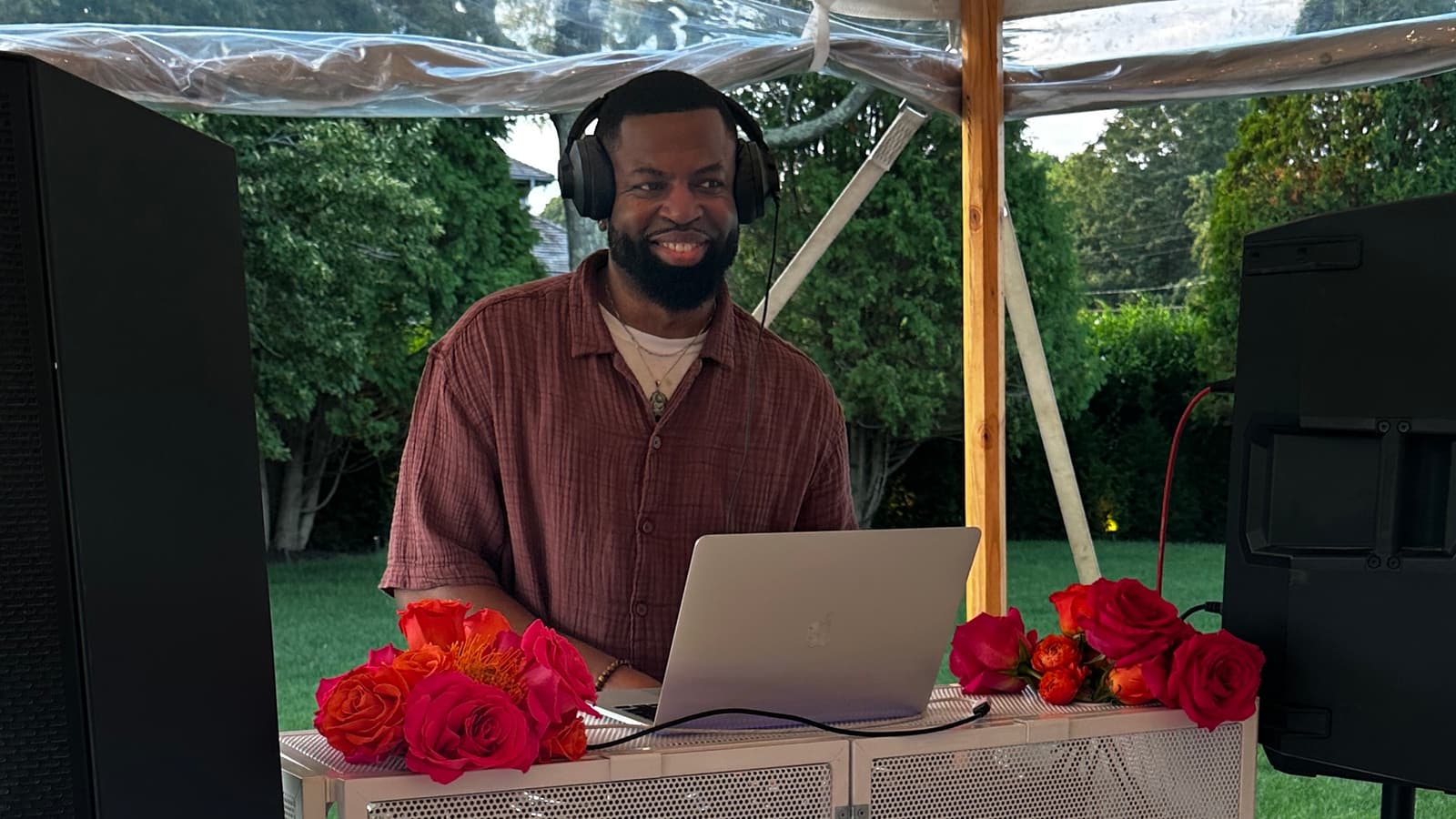 DJ DX performing a golden-hour set under a sailcloth tent at a private Saks Fifth Avenue estate event in Water Mill, NY