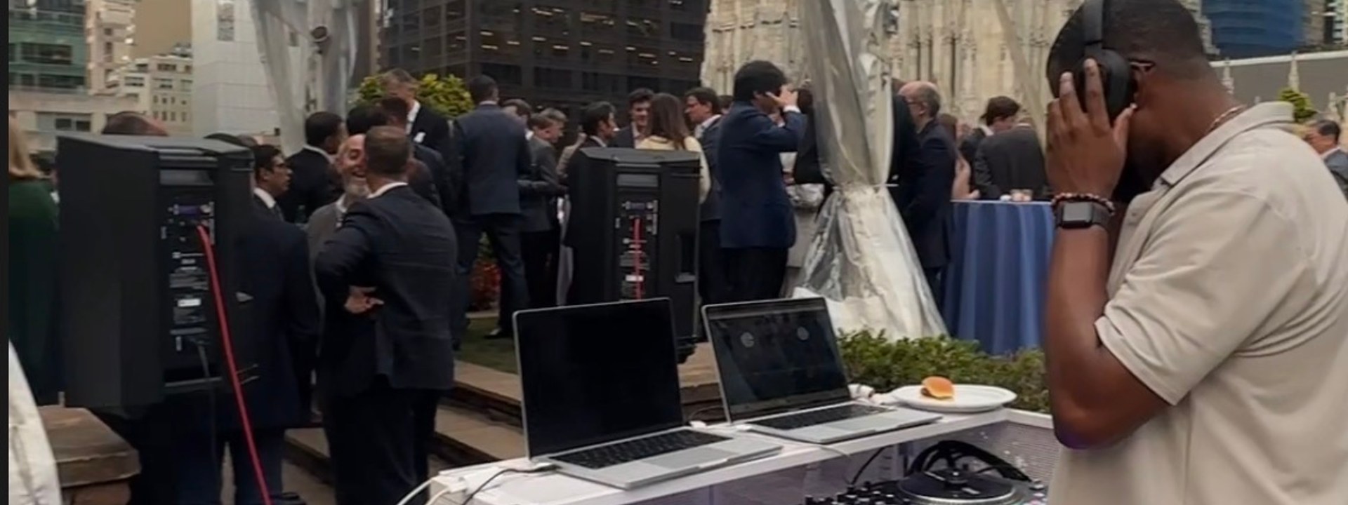 DJ DX at the DJ booth, NautaDutilh corporate reception rooftop, NYC skyline and St. Patrick's Cathedral
