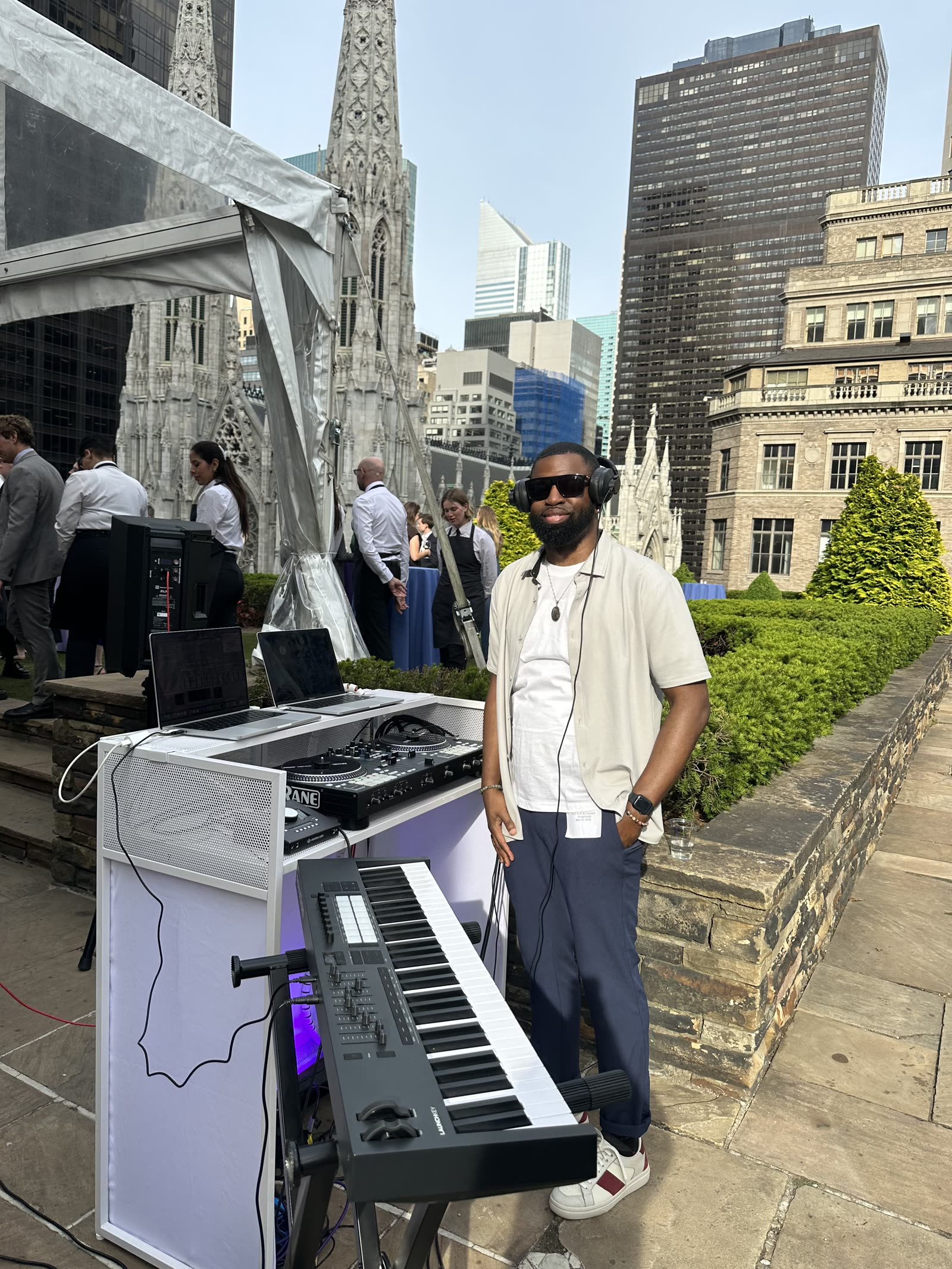 DJ DX performing at the NautaDutilh corporate reception, 620 Loft & Garden rooftop, NYC, with St. Patrick's Cathedral in the background