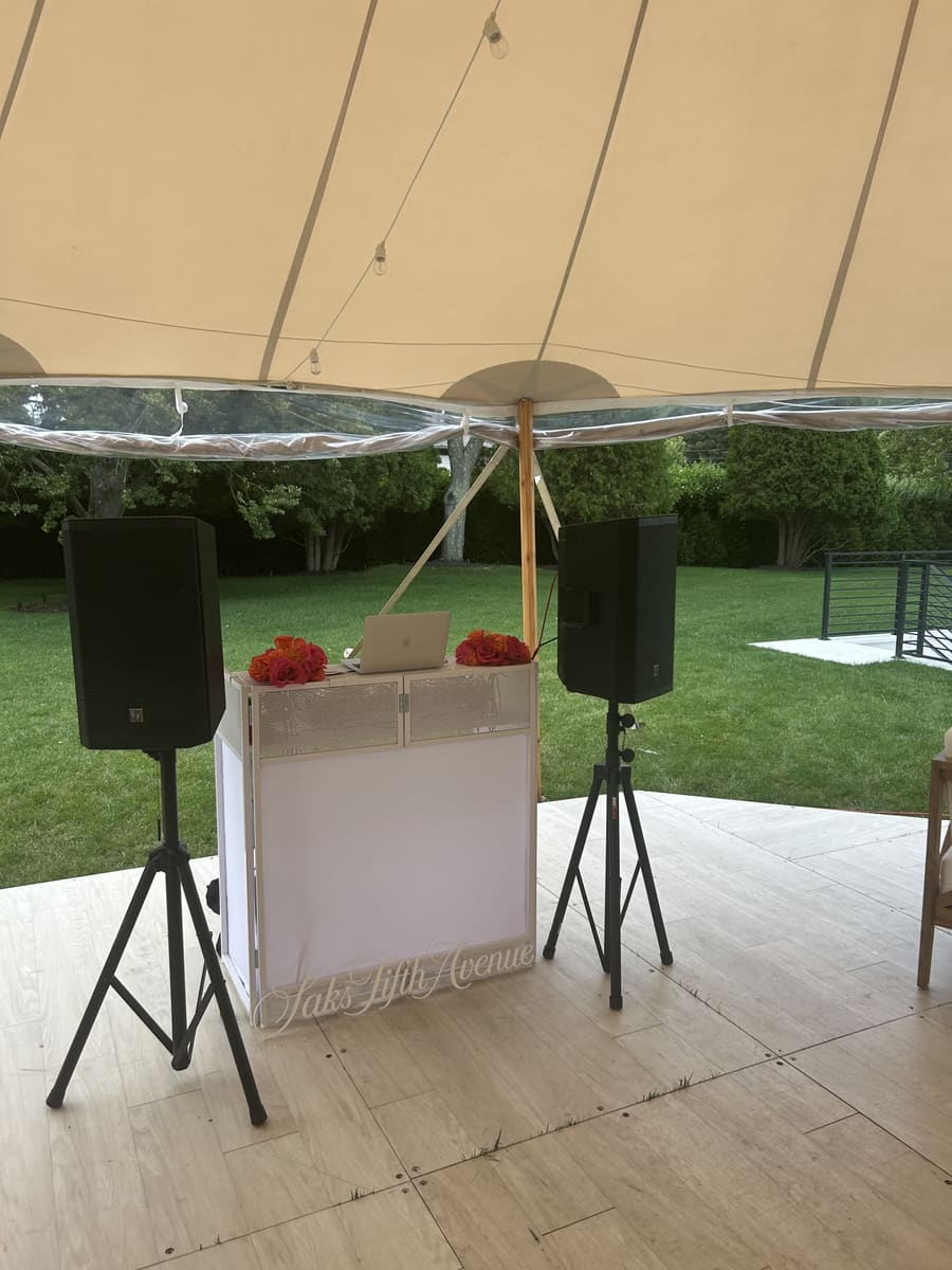 DJ booth under a sailcloth tent at a Saks Fifth Avenue private estate event in Water Mill, New York