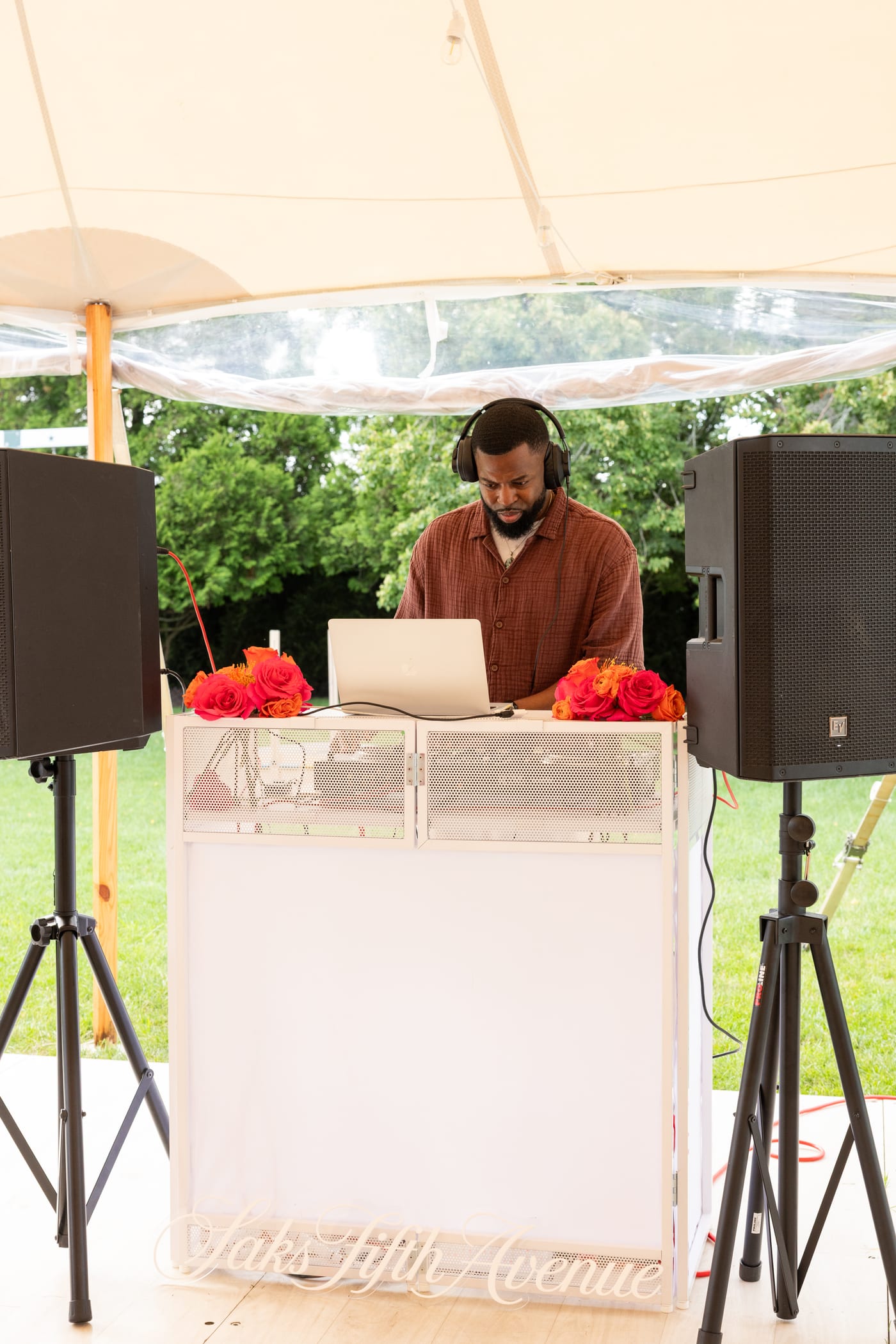 DJ DX and the full DJ booth setup with speakers under the sailcloth tent at a Saks Fifth Avenue private estate event in Water Mill, New York