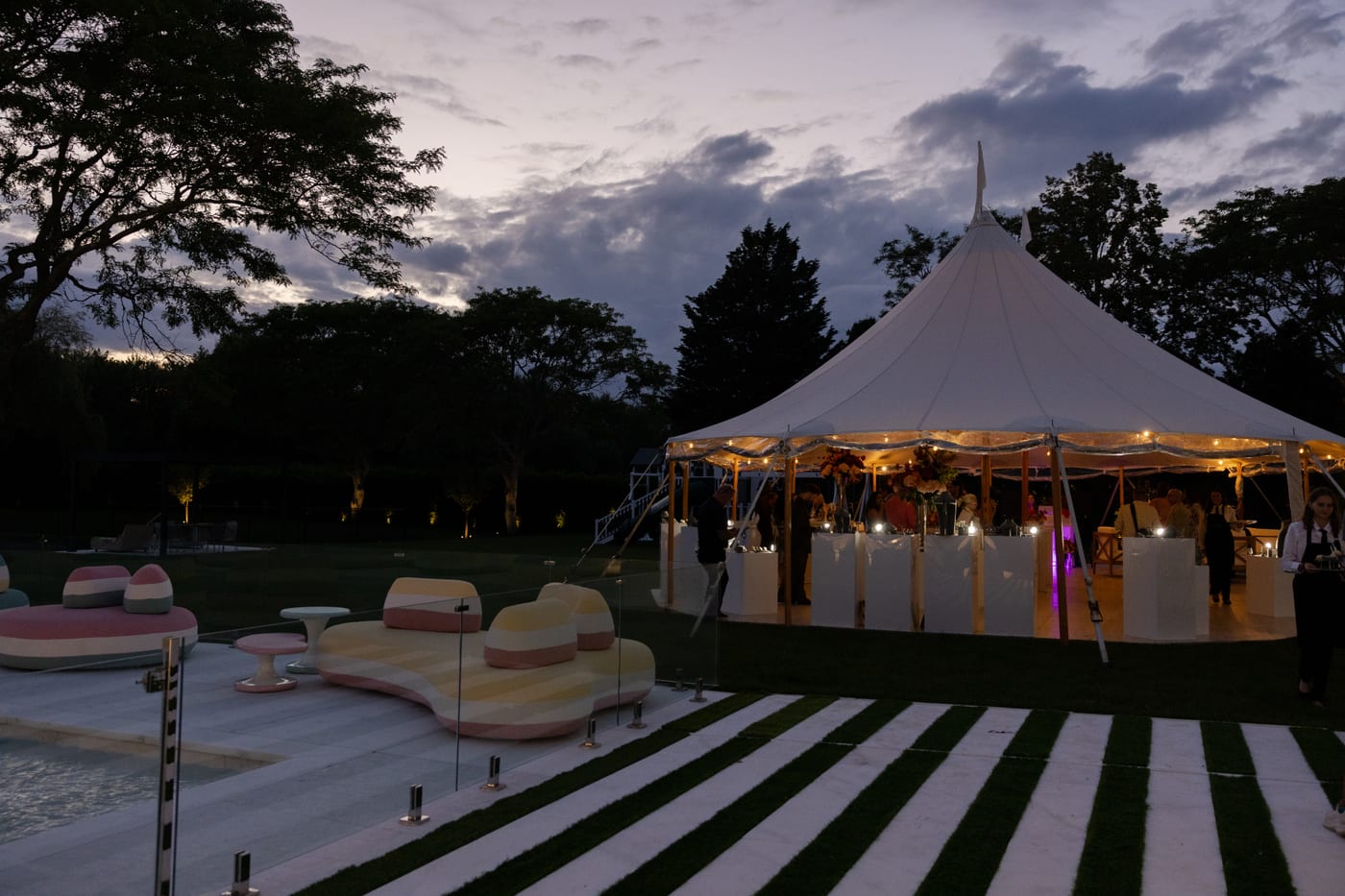 Golden-hour sailcloth tent reception at a Saks Fifth Avenue private estate event in Water Mill, New York