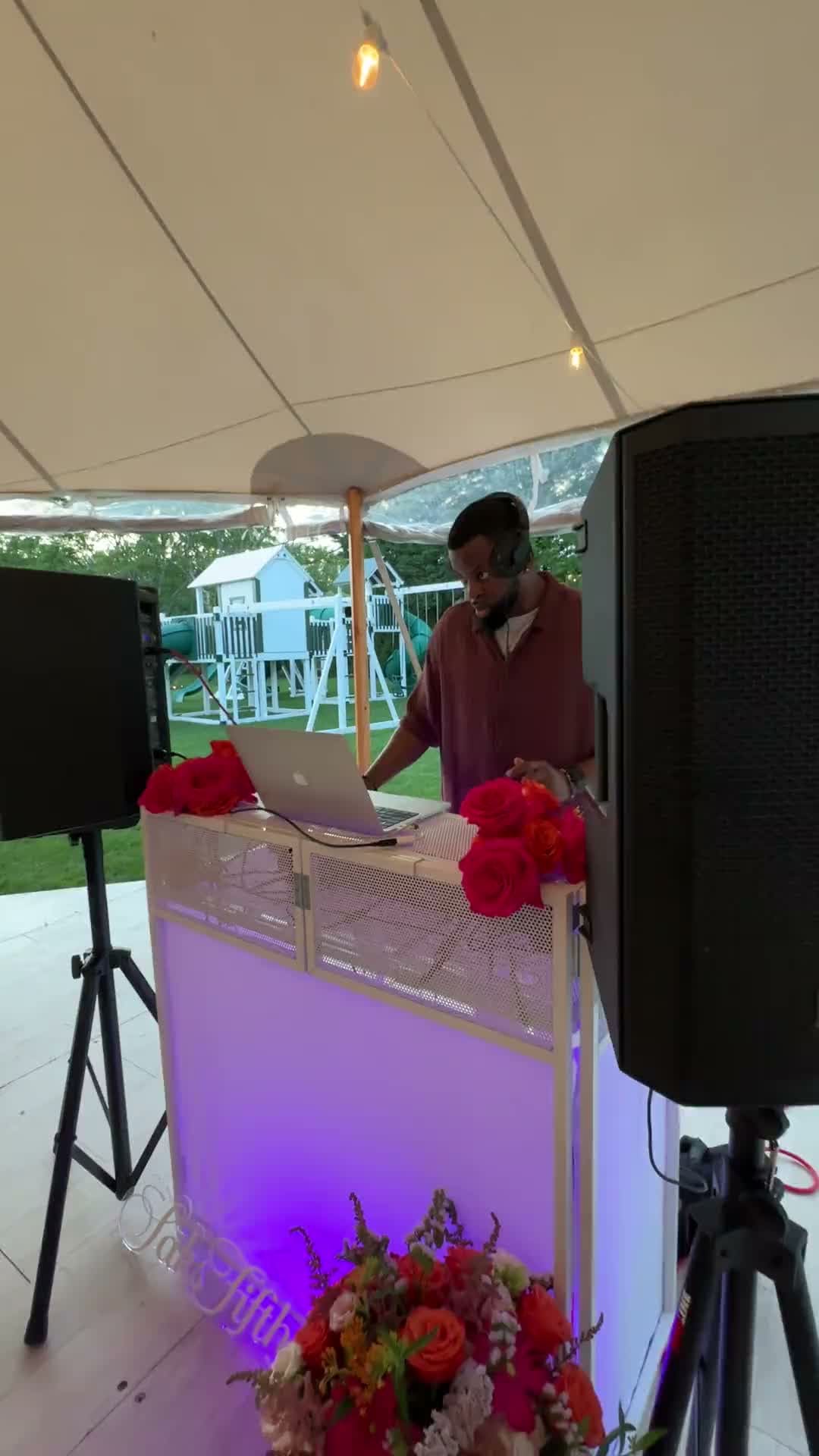 DJ DX djing under a sailcloth tent at a Saks Fifth Avenue private estate event in Water Mill, New York